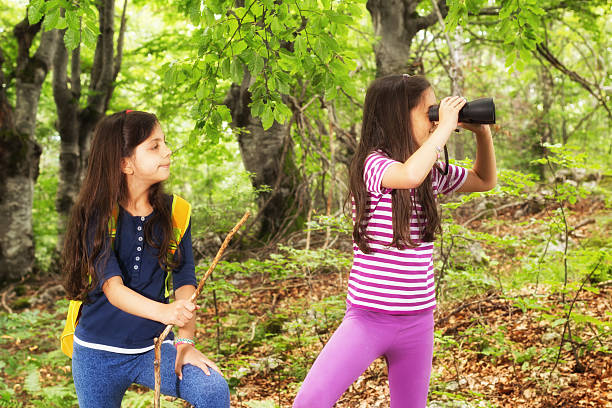 istock Two children in woods looking through binoculars 503207087