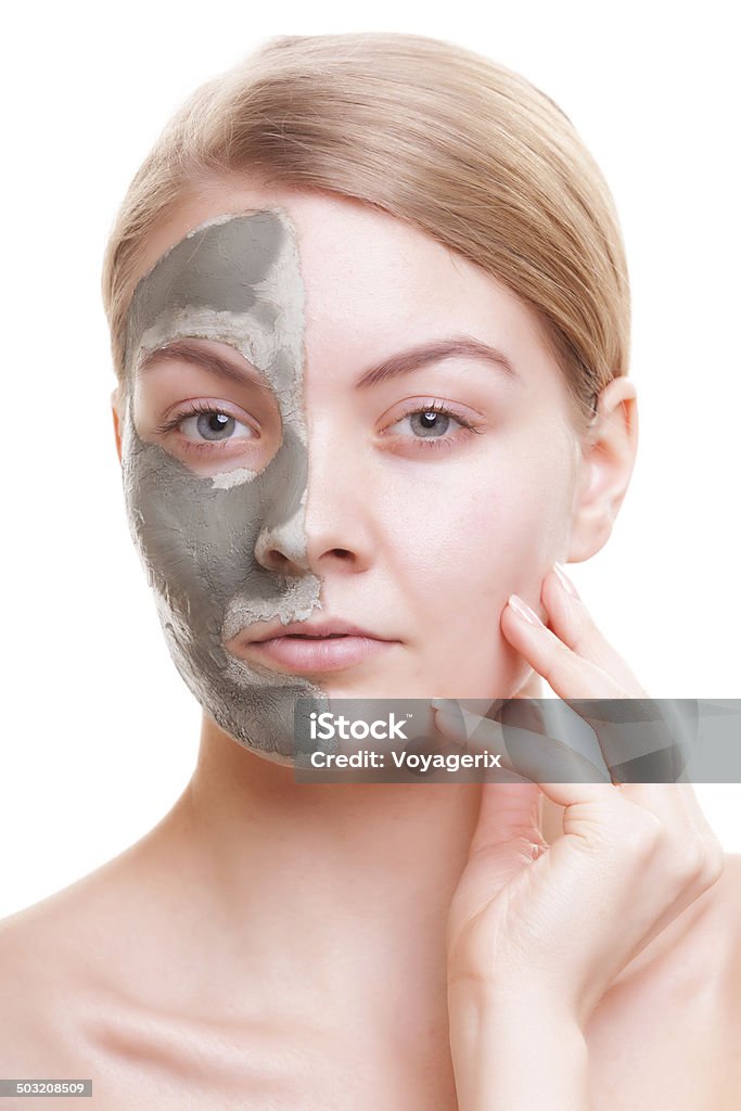 Skin care. Woman applying clay mask on face. Spa. Skin care. Young woman applying clay mask on her face. Girl taking care of her dry compexion. Isolated. Spa and beauty treatment. Acne Stock Photo