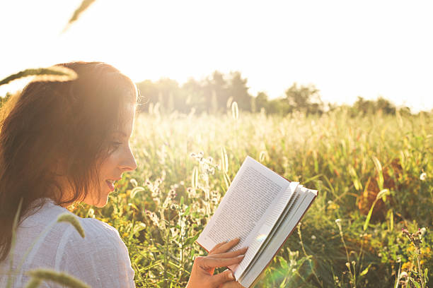 istock girl reading book in the field 503217046