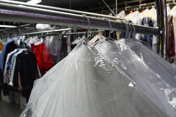 istock Dry cleaned clothes in plastic with business in back 503219651