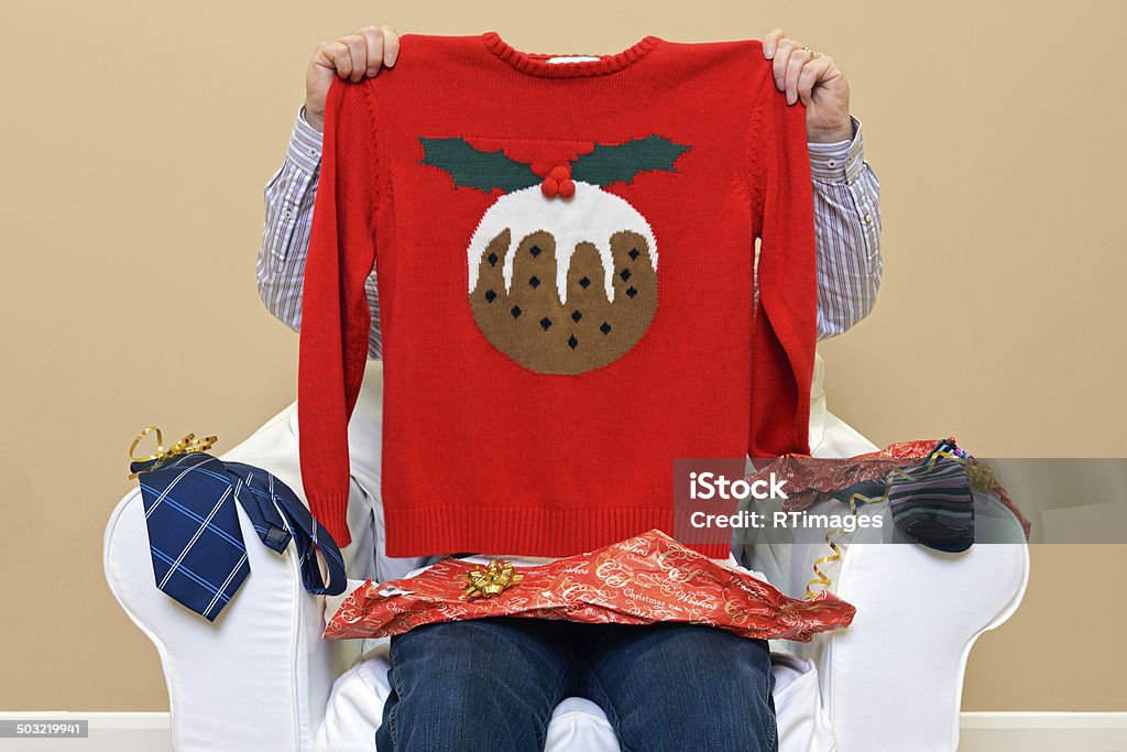 Man - Look what I got for Christmas A man opening Christmas presents to discover he got a Christmas themed jumper to go along with the usual socks and tie. Gift Stock Photo