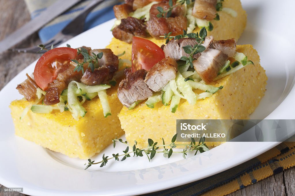Corn porridge with meat, vegetables and thyme Corn porridge with meat, vegetables and thyme on a white plate closeup. horizontal. Bacon Stock Photo