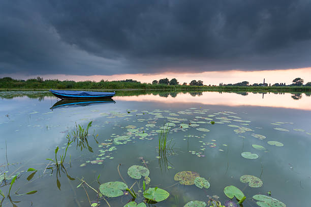 Rowing boat on a small lake in the Ooijpolder near Nijmegen, during a cloudy sunset.