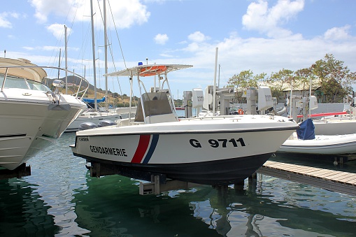 Marigot, Saint Martin (French part) - March 15th, 2015: A twin-engine maritime patrol boat belonging to the Gendarmerie, France's national military police force, sits above the water's surface on a boat-lift in a boatyard on the lagoon near Marigot, Saint-Martin.   