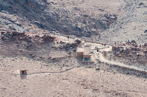 People descend Mount Sinai after having watched the sunrise from its summit. They are passing one of several shops along the trail that connects St. Catherine's Monastery to the summit; a path to an outhouse leads away from the shop.
