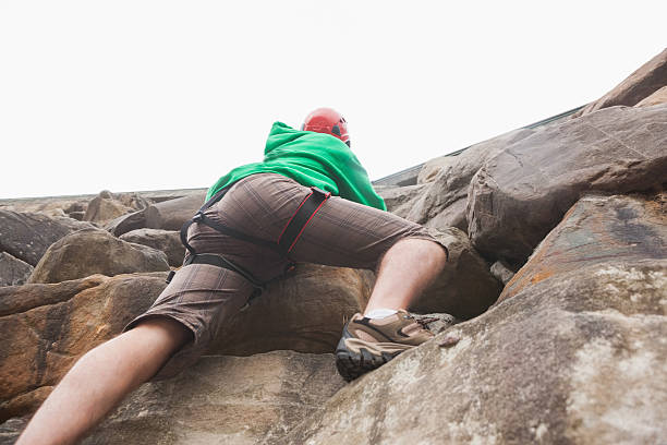 istock Determined man ascending large rock face and seeing the top 503223707