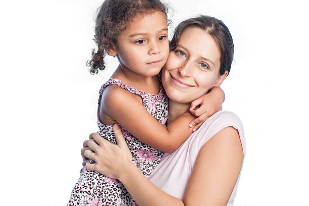 A warm moment featuring a mother embracing her smiling daughter outdoors in a lush park setting. Capturing love, bonding, happiness, and beautiful nature in this emotional and heartfelt scene.
