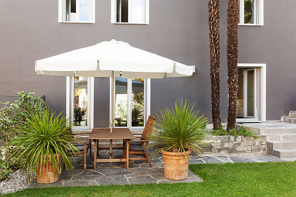 Sunny back deck with table, chairs, and umbrella.