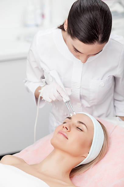 istock Professional young therapist is curing female skin 503239952