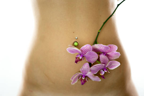 女性のボディ、蘭の花 - pierced abdomen flower beauty ストックフォトと画像
