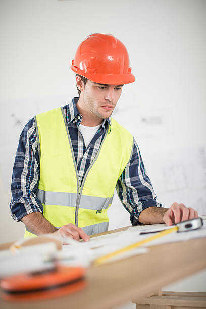istock foreman in his office reviewing building plans 503241107