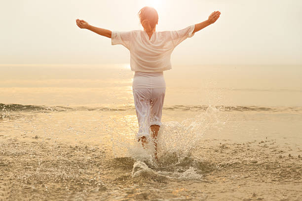 Carefree woman dancing in the sun on the beach