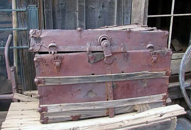 Photo of Old chest displayed on the side of a barn