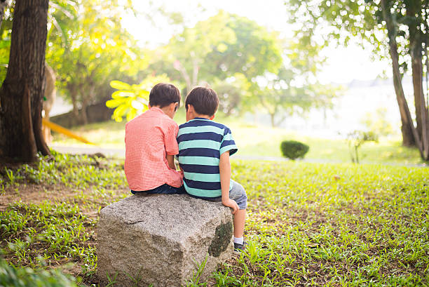 istock Little sibling boy sitting together in the park 503242558