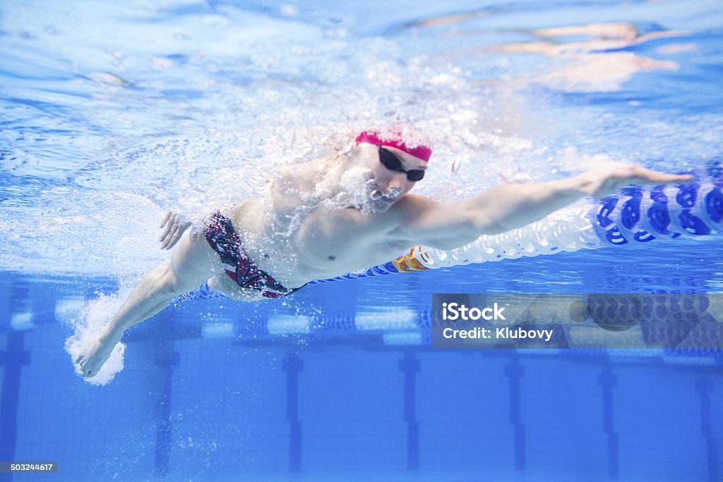 Swimmer speeding through the pool Underwated photo of a young muscular man swimming front crawl style through the olympic swimming pool. Lap Pool Stock Photo