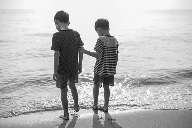 istock Little sibling boy standing on the beach together 503245996