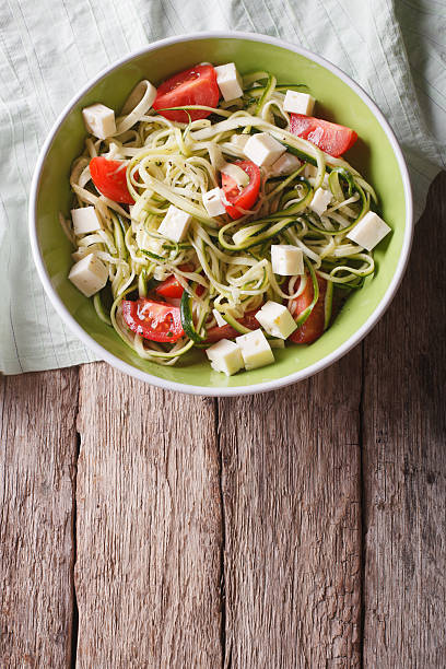 istock zucchini pasta with feta cheese and tomatoes vertical top view 503250622