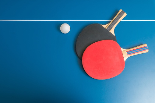 Ping-Pong paddles with ball on table