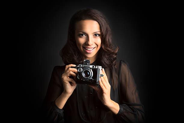 istock Brunette smiling woman holding  a vintage camera 503251836