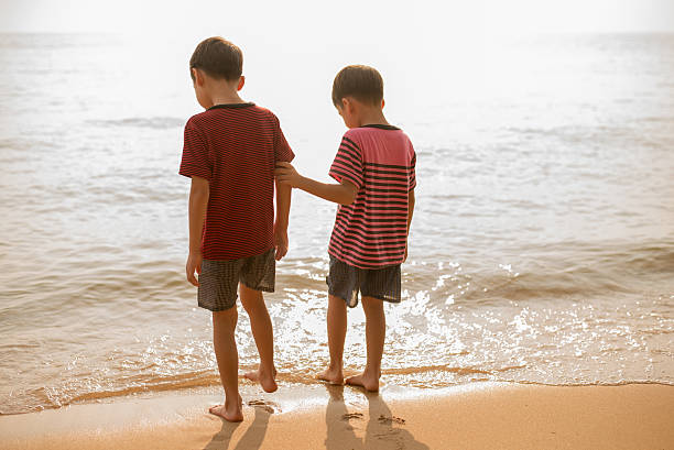 istock Little boy standing together on the beach 503253202