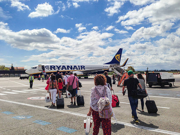 Marseille, France - December 04, 2024: A Ryanair airplane flying high above with its landing gear retracted. The clear blue sky serves as a perfect backdrop, emphasizing the speed and efficiency of commercial air travel.