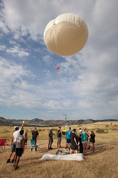 Science team prepares weather balloon Golden Colorado Golden, Colorado, USA - July 26, 2014: Richard Clark (in the hat at the center), Professor of Meteorology at Millersville University in Pennsylvania and his students prepare an air testing payload to be carried by a tethered weather balloon for a national air quality project. weather balloon stock pictures, royalty-free photos & images