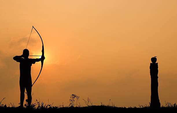 istock Silhouette archery shoots a bow at an apple on timber 503258013