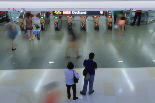 Singapore, Singapore - 26 May, 2014: Tourists and local people travel at Orchard MRT station in Singapore.