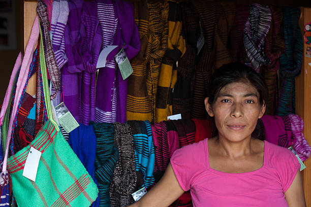 Portrait of a Mayan woman in front of woven textiles. stock photo