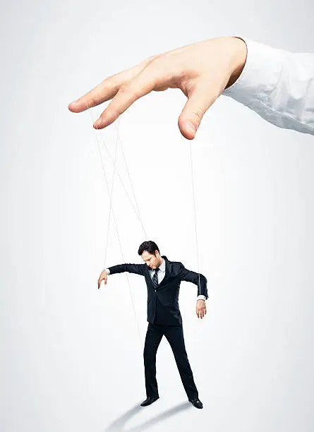 Businessman marionette on ropes controlled  hand