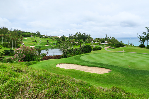 An lovely shot of a green and bunker overlooking the sea