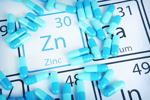 Zinc - Mineral Supplement on Periodic Table Zinc with capsules or pills on the periodic table (Periodic table made by me) Stock image representing mineral supplementation. vitamins and minerals chart stock pictures, royalty-free photos & images