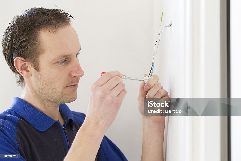 Young man installing electricity A 30 years old man is installing the electricity in his new house. 30-34 Years Stock Photo