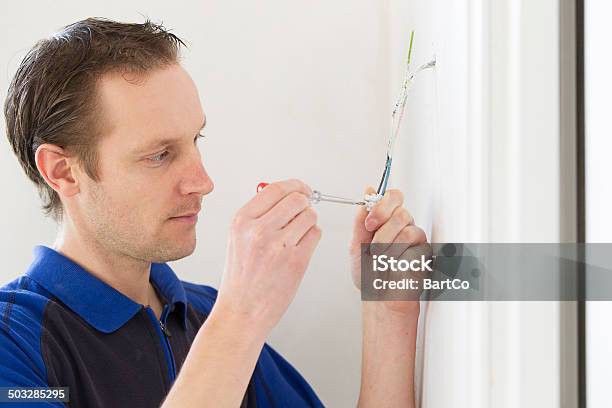 Young Man Installing Electricity Stock Photo - Download Image Now - 30-34 Years, 30-39 Years, Adult