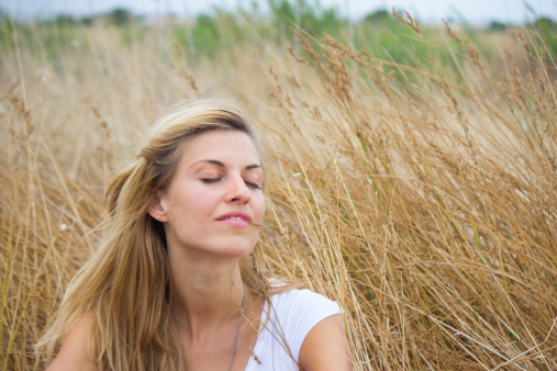 Beautiful woman relaxing in hay field, face, copy space