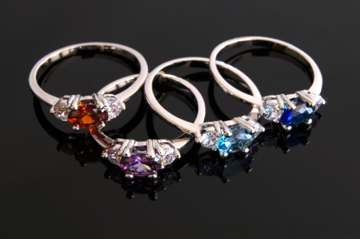 Birthstone rings on black background. Ruby, sapphire, diamond, aquamarine and amethyst.