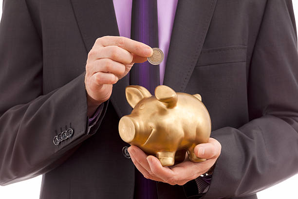 istock Business man putting coin into piggy 503289821