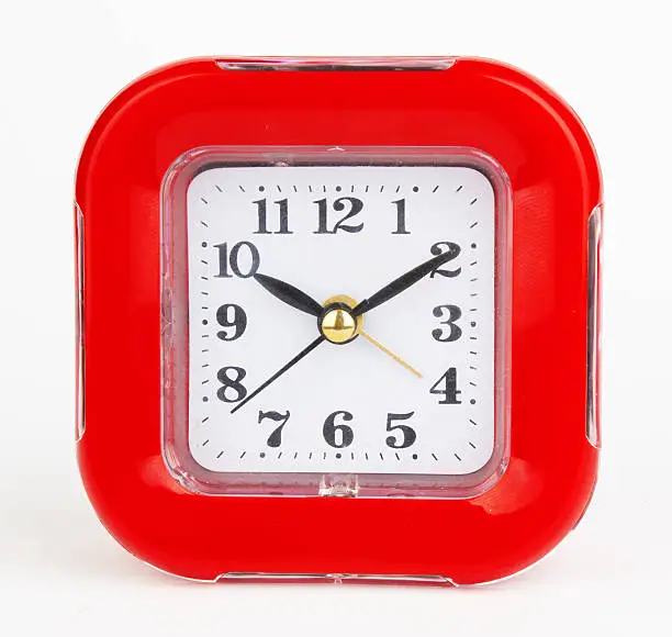 red alarm clock on a white background