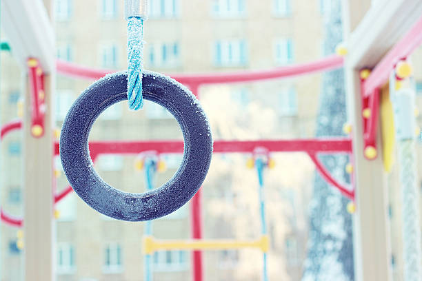 Freezing gymnastic rings. Snowy playground. Frost. stock photo