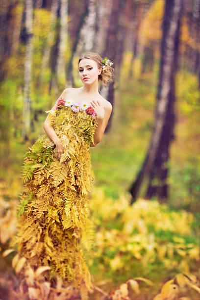 Beautiful woman in dress made with fern leaves. stock photo