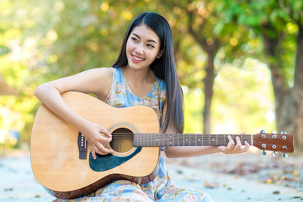 mujer tocando la guitarra - sunny cantante fotografías e imágenes de stock