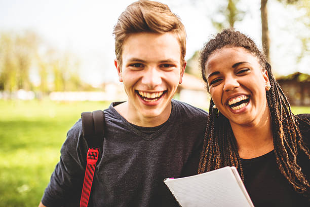 paar teenager-student im freien lachen - child education group of people student stock-fotos und bilder