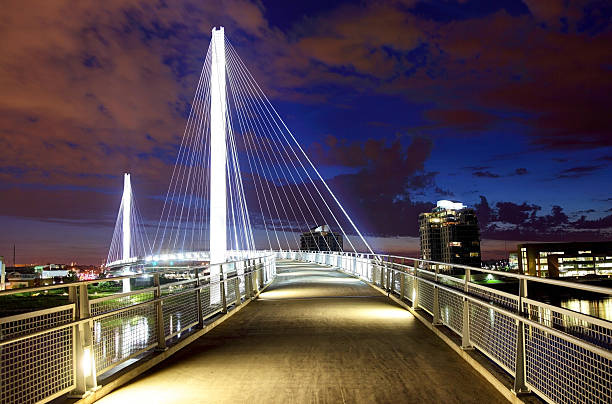 Bob Kerrey Pedestrian Bridge The Bob Kerrey Pedestrian Bridge footbridge across the Missouri River between Council Bluffs, Iowa, and Omaha, Nebraska at night. Omaha is the largest city in the state of Nebraska.  Omaha is known for is steak, hospitality, performance venues, museums, musical heritage nature and cultural experiences footbridge stock pictures, royalty-free photos & images