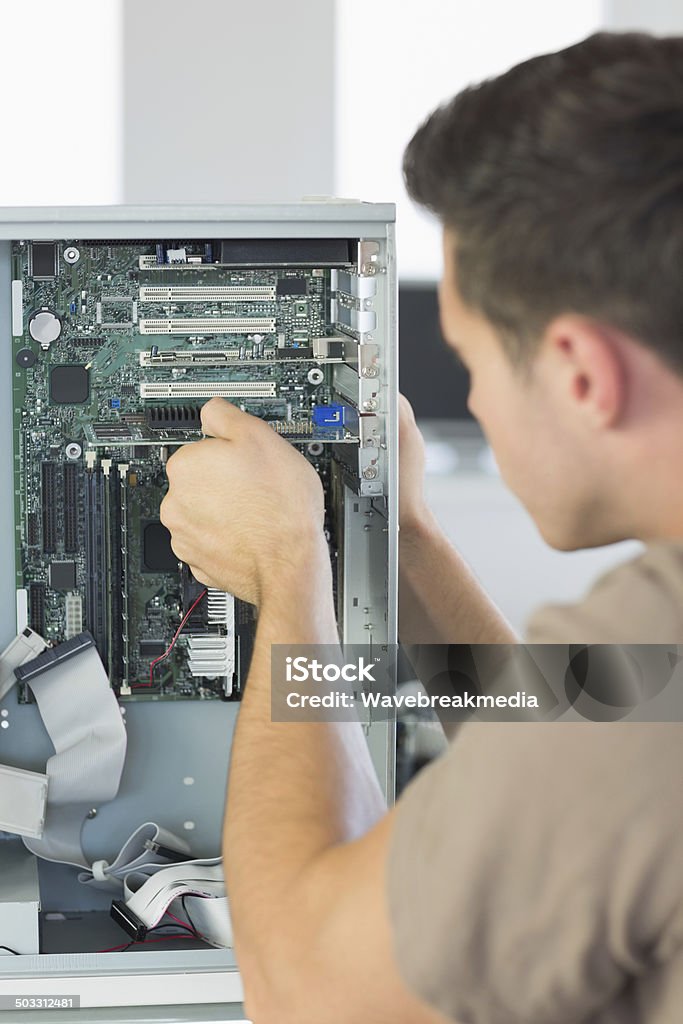 Engineer repairing Computer Computer engineer repairing computer in bright office 20-29 Years Stock Photo