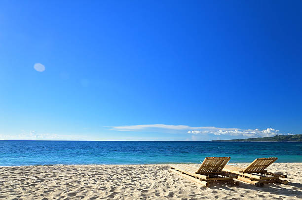 istock Two sunbeds at tropical sandy beach 503318427