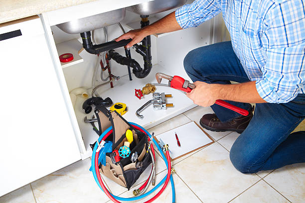 Plumber on the kitchen. stock photo