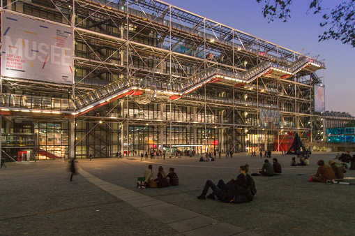 Paris, France - September 30, 2015: Facade of the Centre Pompidou (Beauborg), Paris, France. It is early in the evening and some people are sitting on the square in front of the museum.