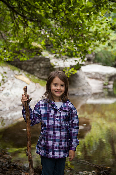 istock girl playing by river 503327104