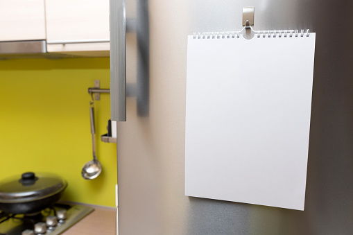 white blank paper sheet hanging on fridge door