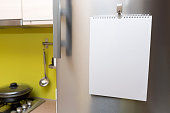 blank paper sheet hanging on fridge door